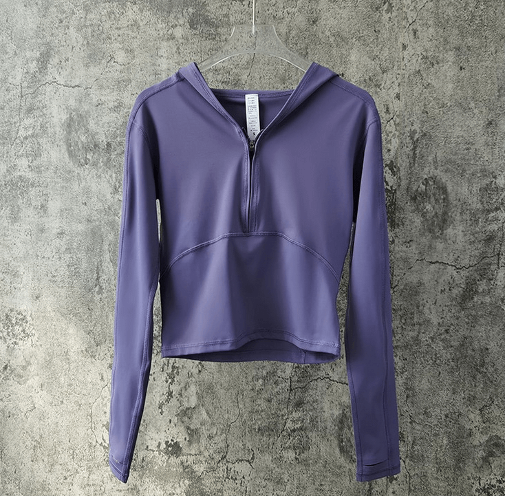 Stylish sports women's top in purple with long sleeves and hood, perfect for yoga, made from breathable nylon-spandex blend.